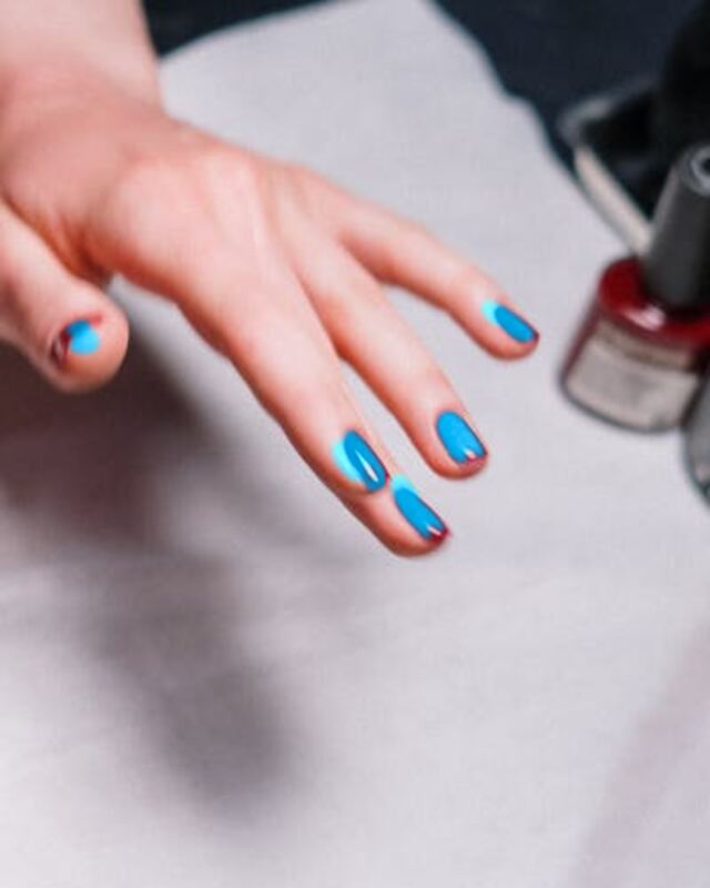 The same hand with blue nail polish, made with LooksAI
