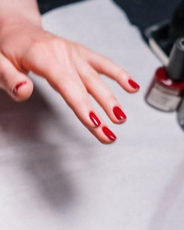 Hand with red nail polish, before LooksAI